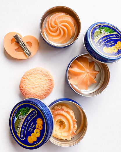 Butter cookies in tins on a white background