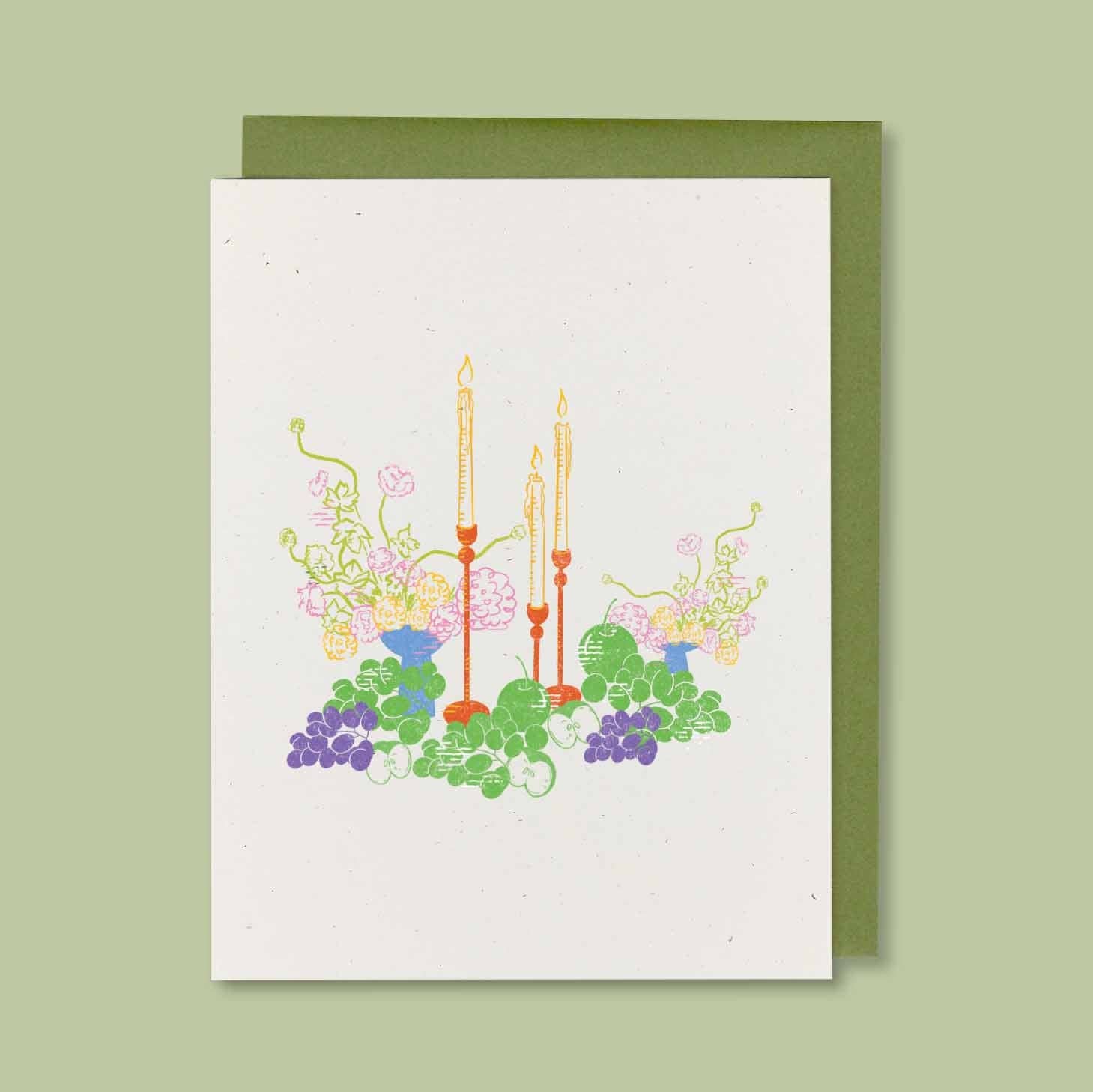 Greeting card with floral and candle design on a green background