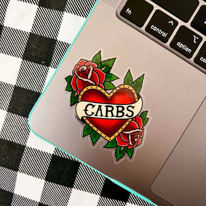Heart-shaped tattoo design with roses and 'CARBS' text on a laptop