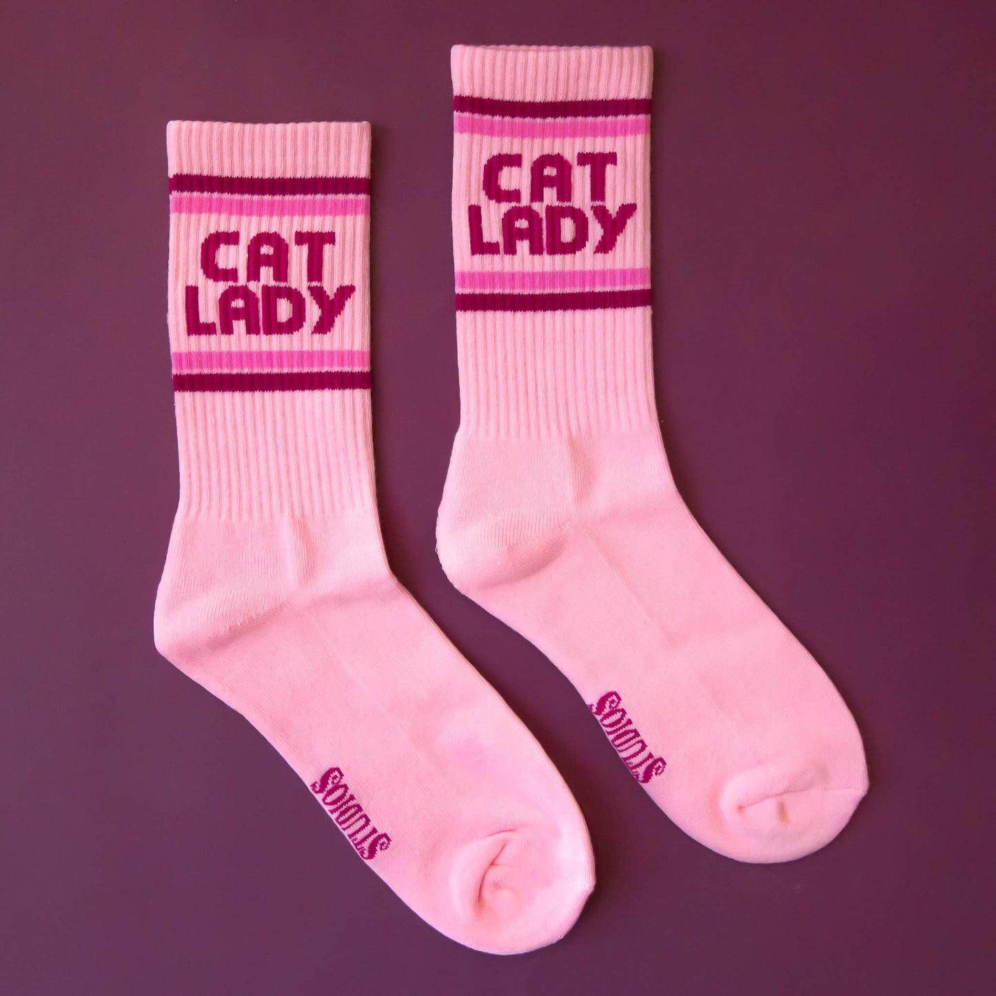 Pink socks with 'CAT LADY' text on a purple background