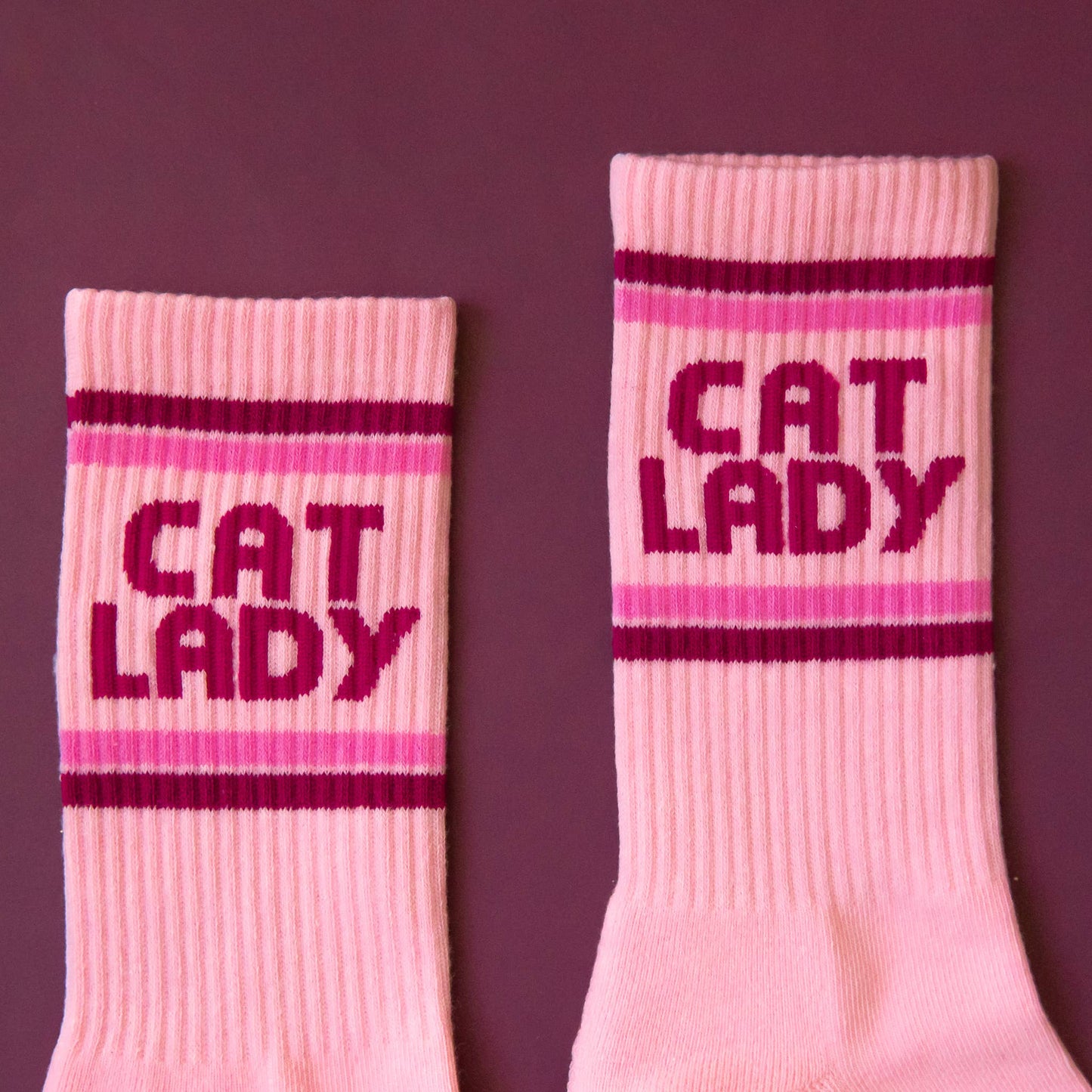Pink socks with 'CAT LADY' text on a purple background