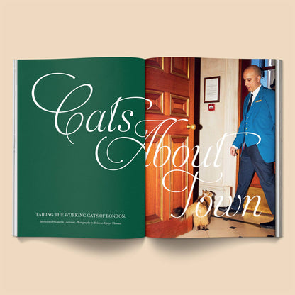 Book titled 'Cats About Town' with a man in a blue suit and dog on a beige background