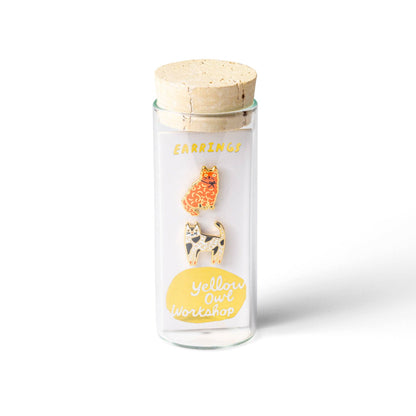 Glass jar with wooden lid containing animal-themed pins on a white background