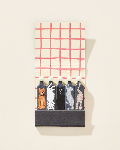 Set of cat-themed matches in a decorative holder with a plaid pattern on a white background.