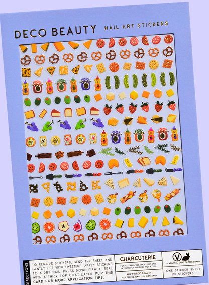 Sheet of Deco Beauty nail art stickers with various food-themed designs on a blue background. Charcuterie Nail Art Stickers