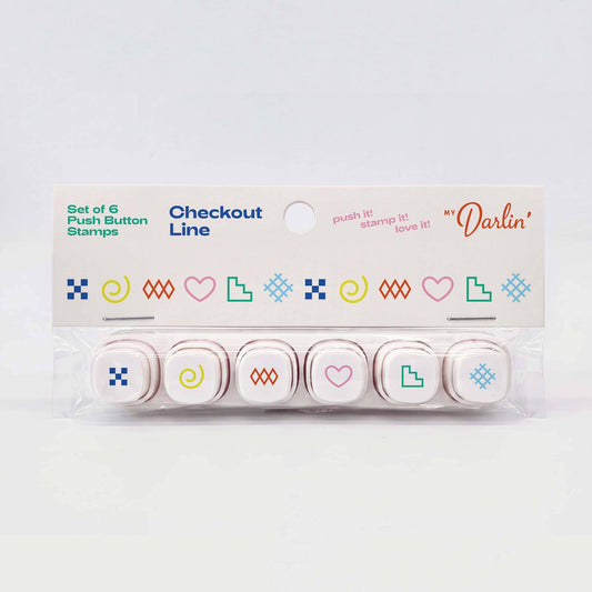 A set of six checkout push button stamps in a clear plastic clamshell package with a white cardboard header card. The stamps feature minimalist colorful icons including hearts, squares, spirals, and geometric shapes in blue, green, pink, yellow, and orange.