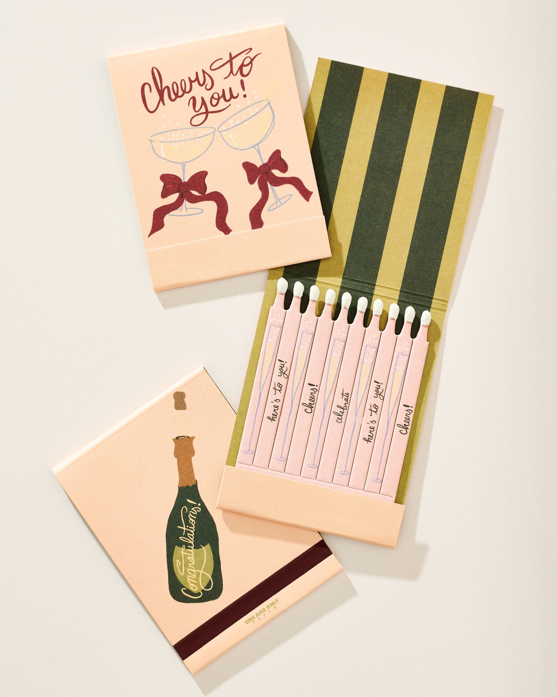 Set of cards with champagne bottle and bow designs on a light background