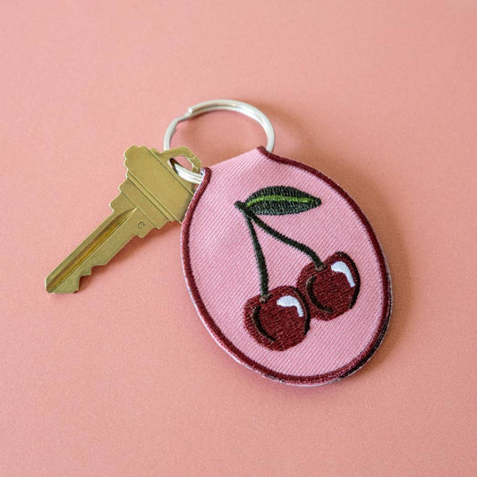 Keychain with cherry design on a pink background