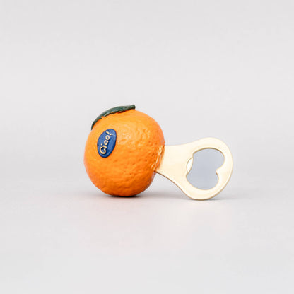 An orange-shaped bottle opener with a white handle and a blue C&H logo, set against a plain light gray background.