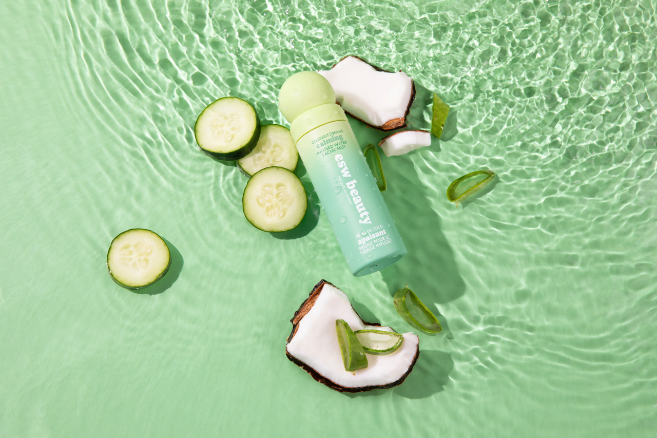 Skincare product with cucumber slices and aloe vera on a green water background
