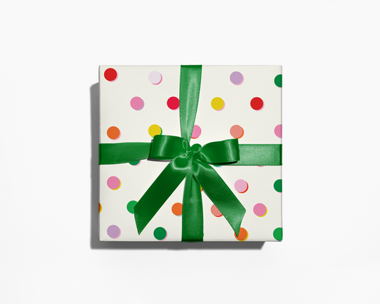 Gift box with colorful polka dots and a green ribbon on a white background
