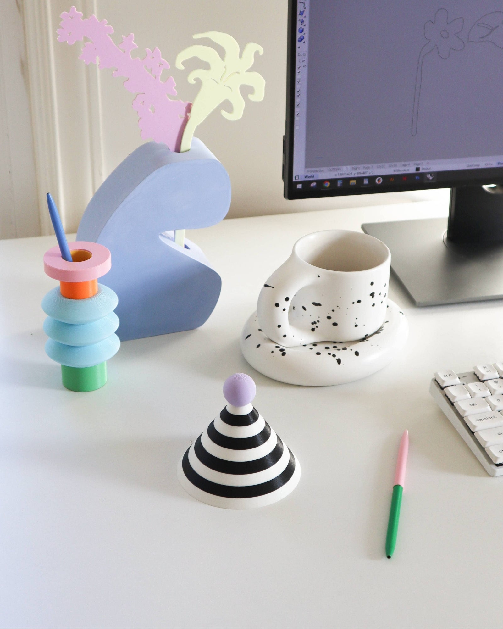 Colorful desk accessories on a white desk with a computer monitor in the background