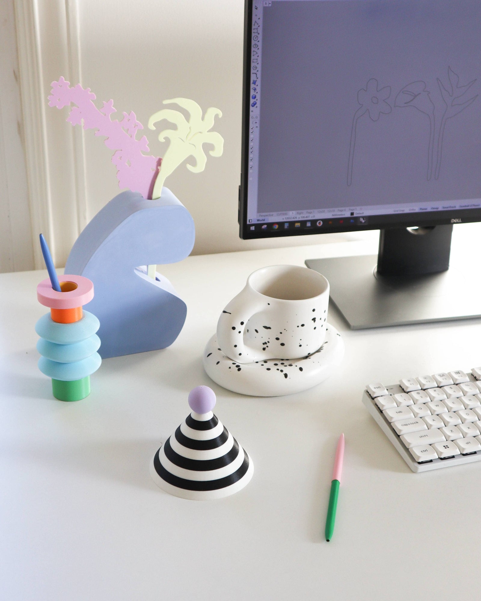 Colorful desk accessories on a white desk with a computer monitor in the background