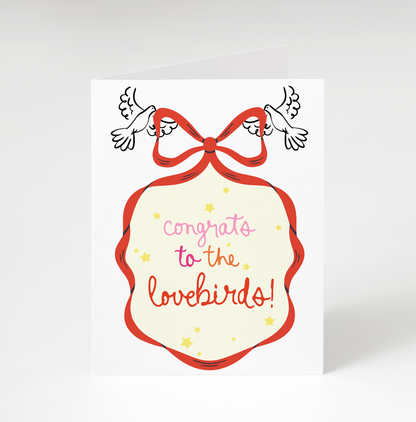 Card with 'Congrats to the lovebirds!' text and a red bow on a white background