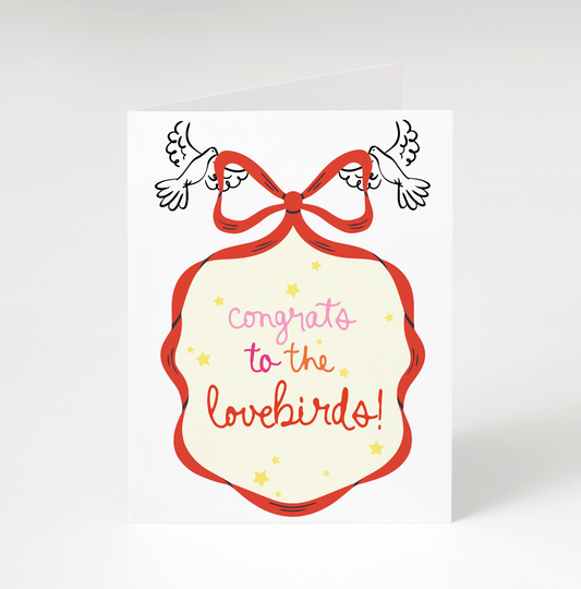 Card with 'Congrats to the lovebirds!' text and a red bow on a white background