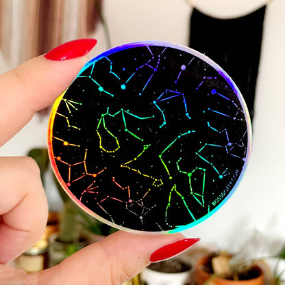 Glowing disc with colorful constellation design held by a hand.
