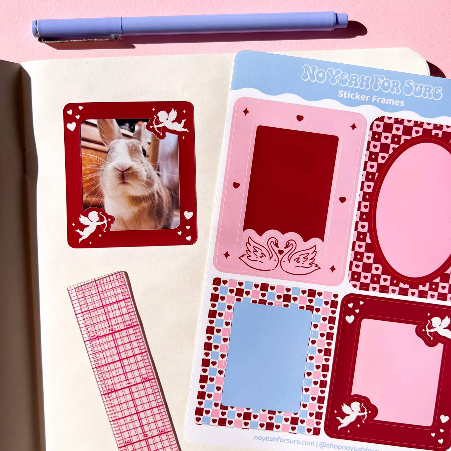 A styled flat-lay of planner stickers featuring decorative photo frames in pink, red, and blue, shown next to a pen and a pink-and-white grid washi tape on a pink background. The sticker sheet is branded 'NoYanForSure'.