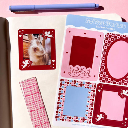 A styled flat-lay of planner stickers featuring decorative photo frames in pink, red, and blue, shown next to a pen and a pink-and-white grid washi tape on a pink background. The sticker sheet is branded 'NoYanForSure'.