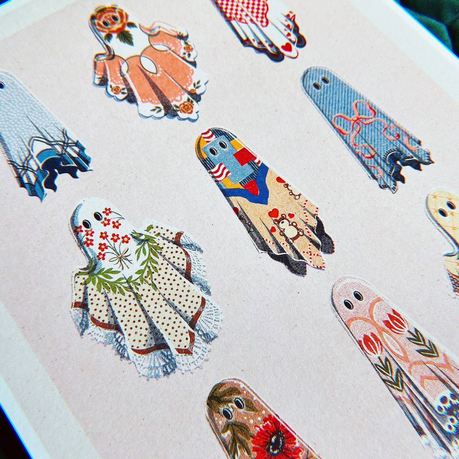 Collection of colorful paper dolls on a textured surface, Cozy Ghosts Art Print, chaos magic studio