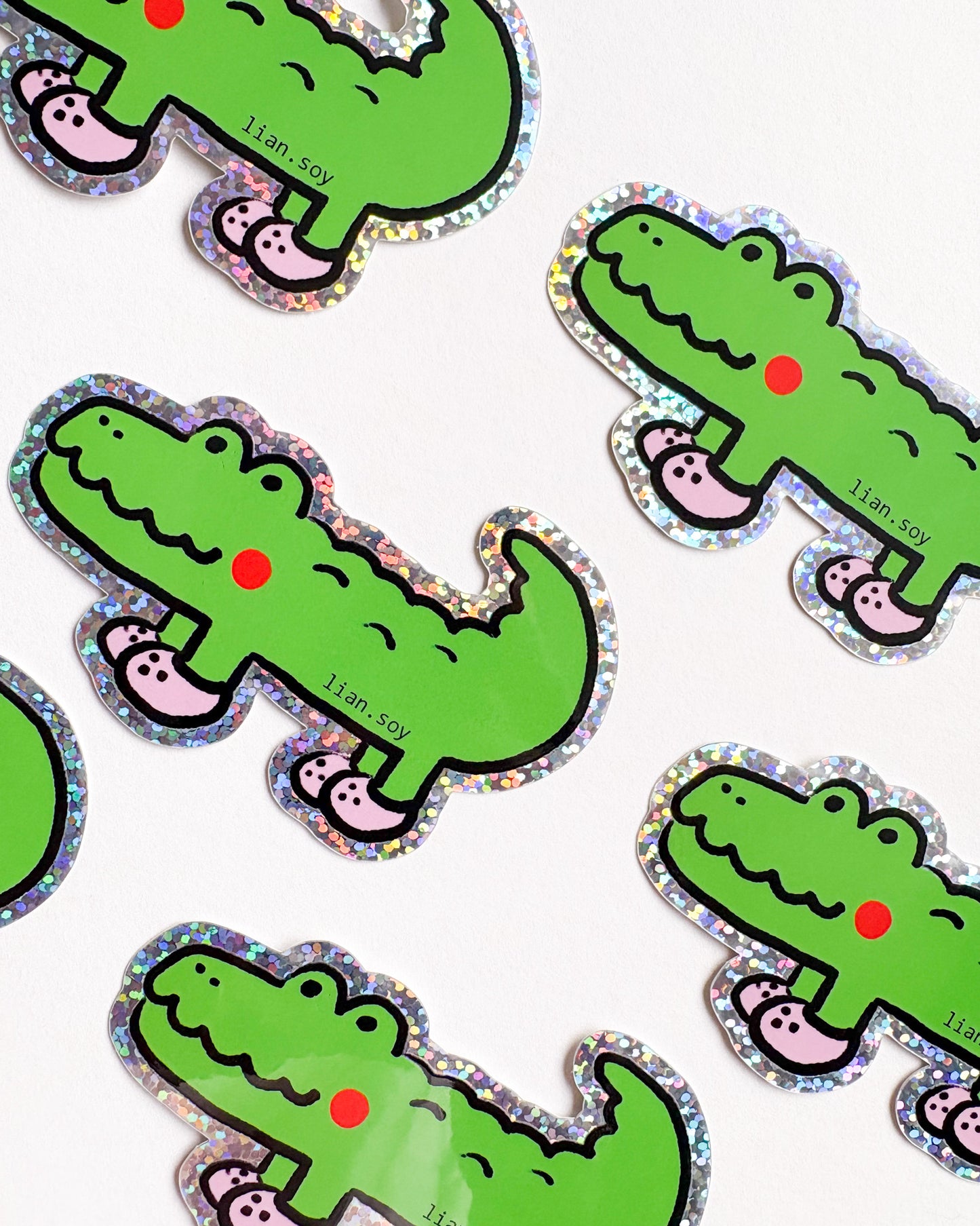 Pattern of green cartoon alligators with pink feet on a white background