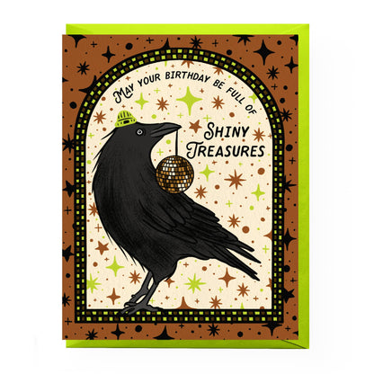 Greeting card with a black crow holding a disco ball and celebratory text on a patterned background.