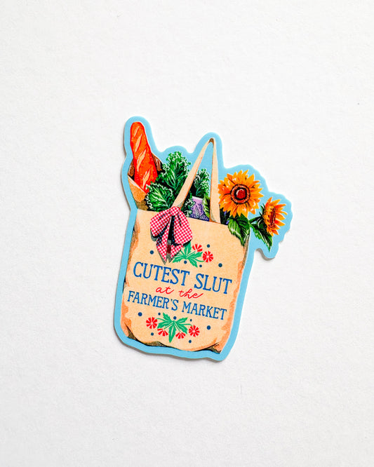 Colorful magnet shaped like a shopping bag with vegetables and flowers, featuring text on a white background.