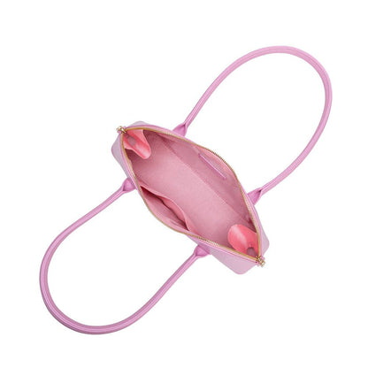 Pink handbag with a strap on a white background