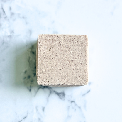 Square beige bar of soap on a marble surface
