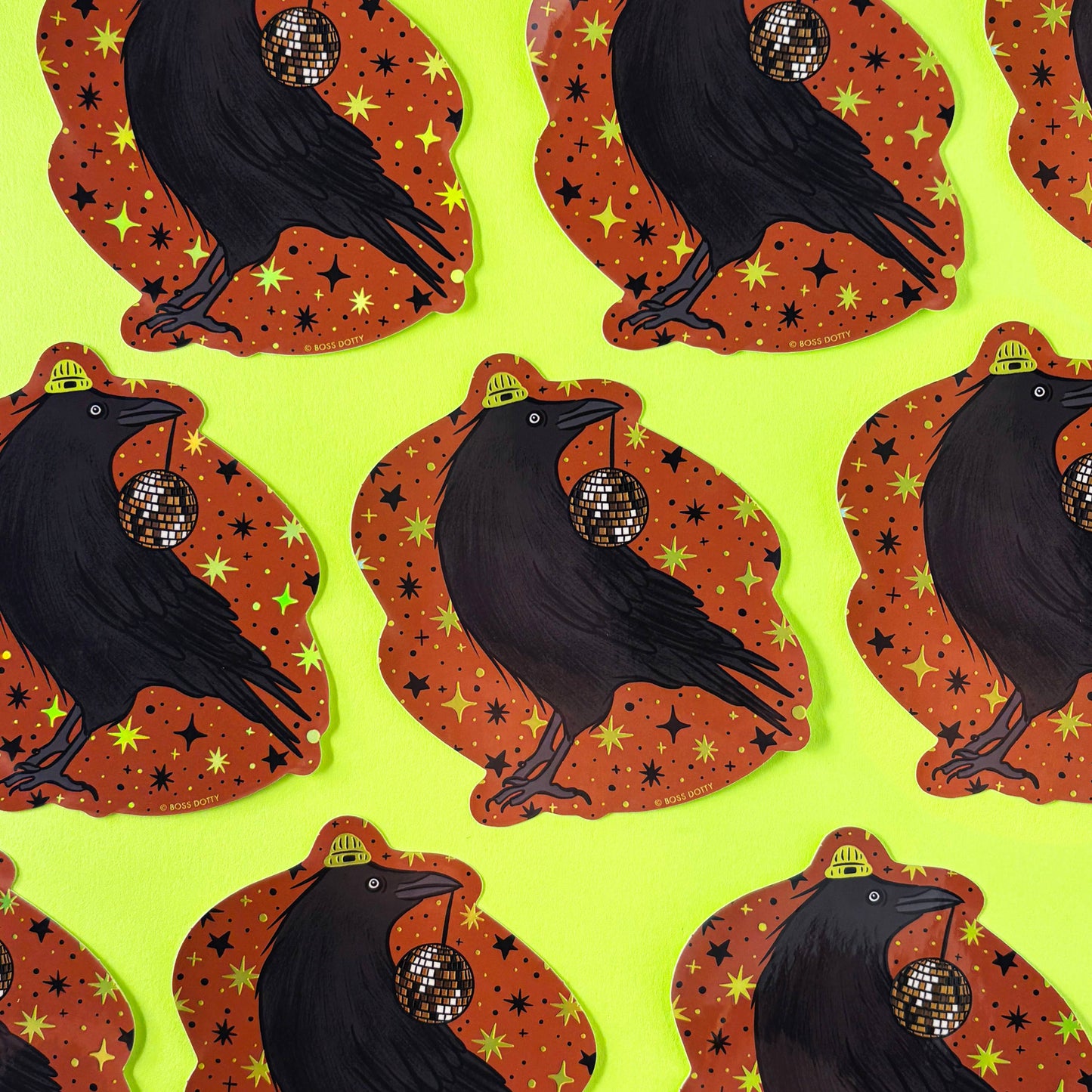 Pattern of black crows with disco balls on orange backgrounds against a green background