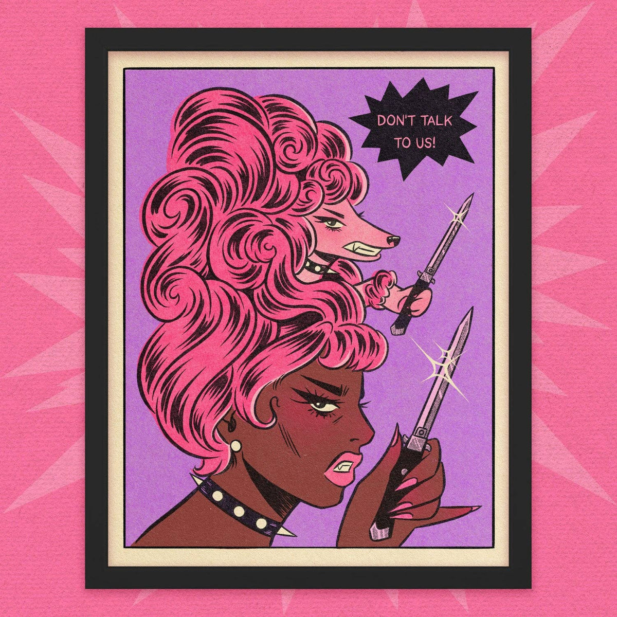 A framed pop-art print featuring two illustrated women with pink hair and knives, with a black starburst reading 'DON'T TALK TO US!' on a purple background, set against a pink patterned backdrop.