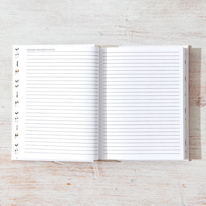 Open notebook with lined pages on a light wooden surface, Dream Journal