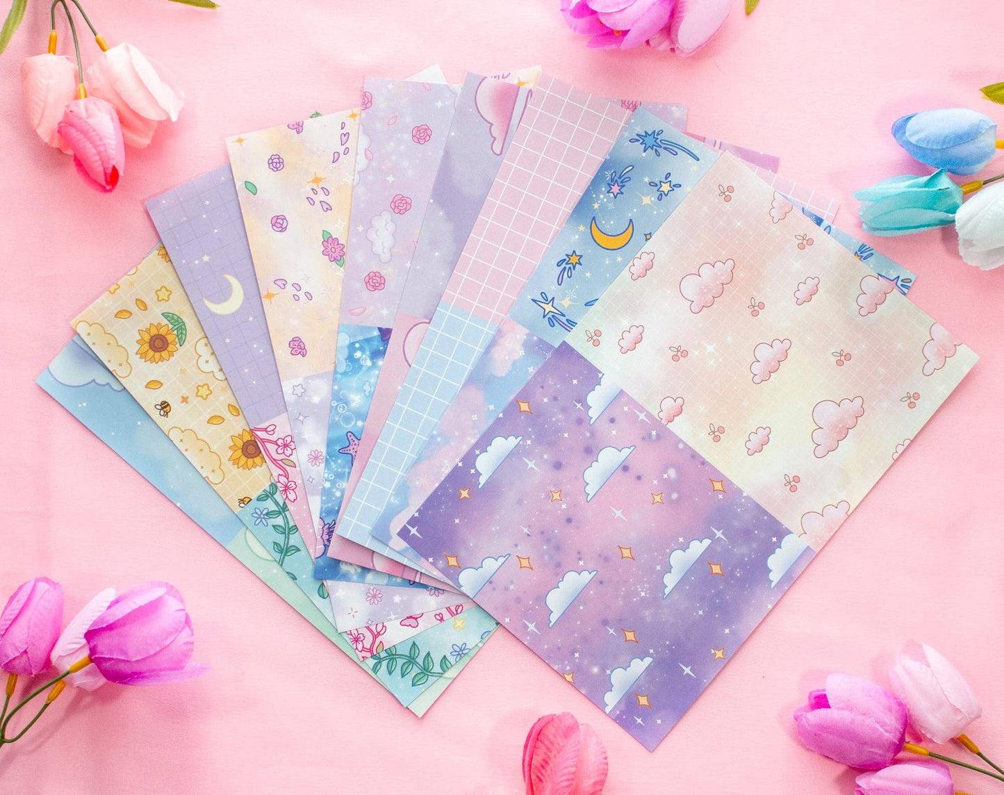 Set of colorful stationery sheets with various designs on a pink background with flowers.