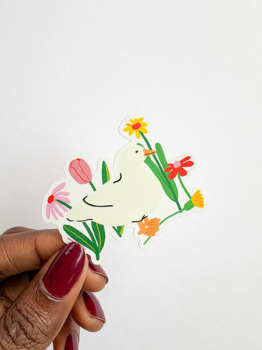 Hand holding a sticker of a dove with flowers on a white background