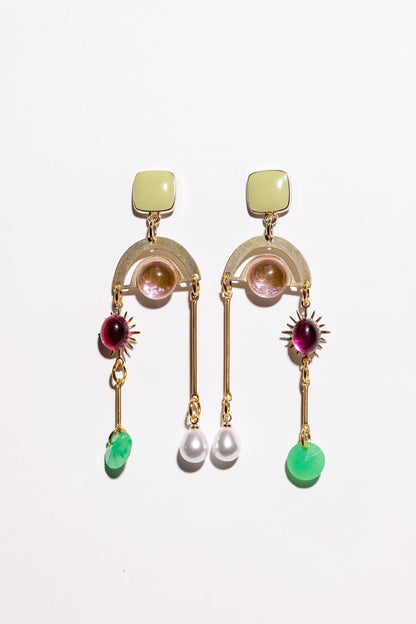 Pair of gold earrings with gemstones and pearls on a white background