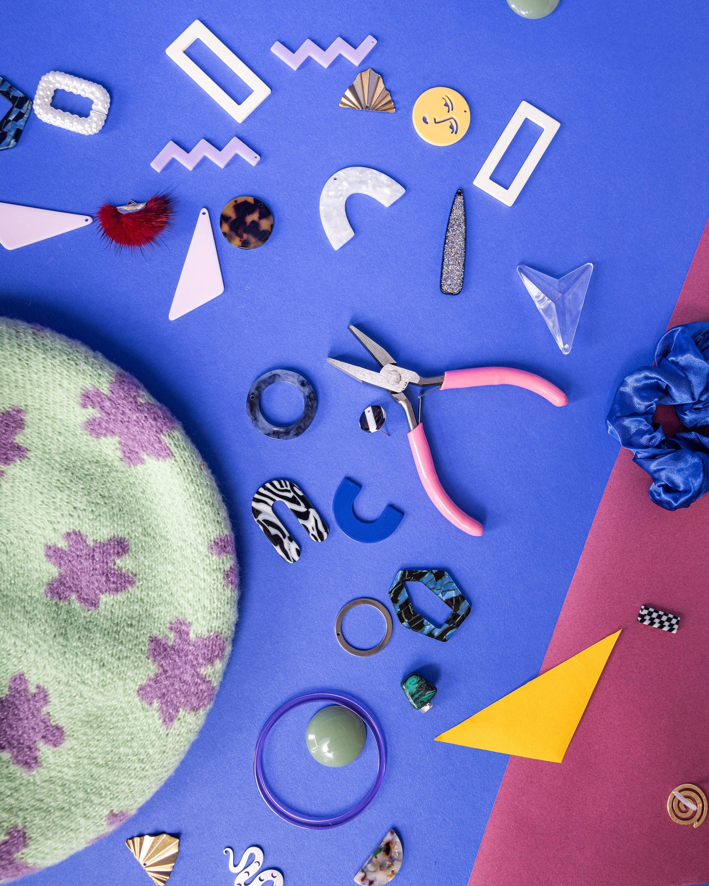 Colorful jewelry-making supplies on a blue background