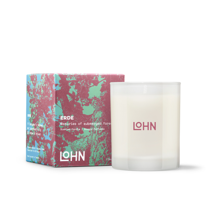White candle with 'LOHN' branding next to its packaging on a white background