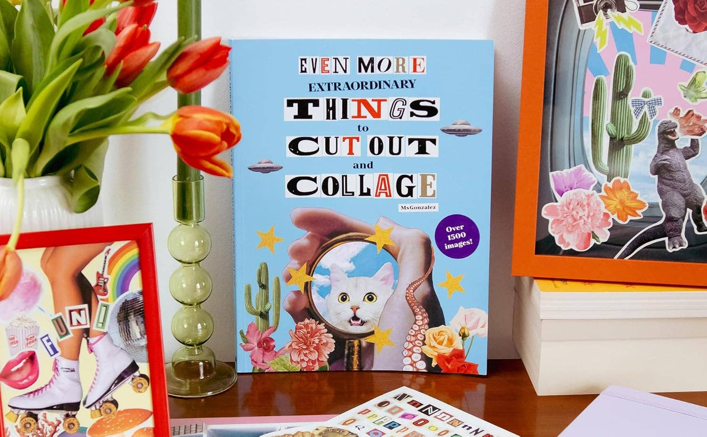 Collage book and craft materials on a table with flowers and framed pictures.