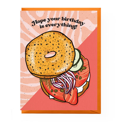 Greeting card with a bagel sandwich illustration and text on a pink background