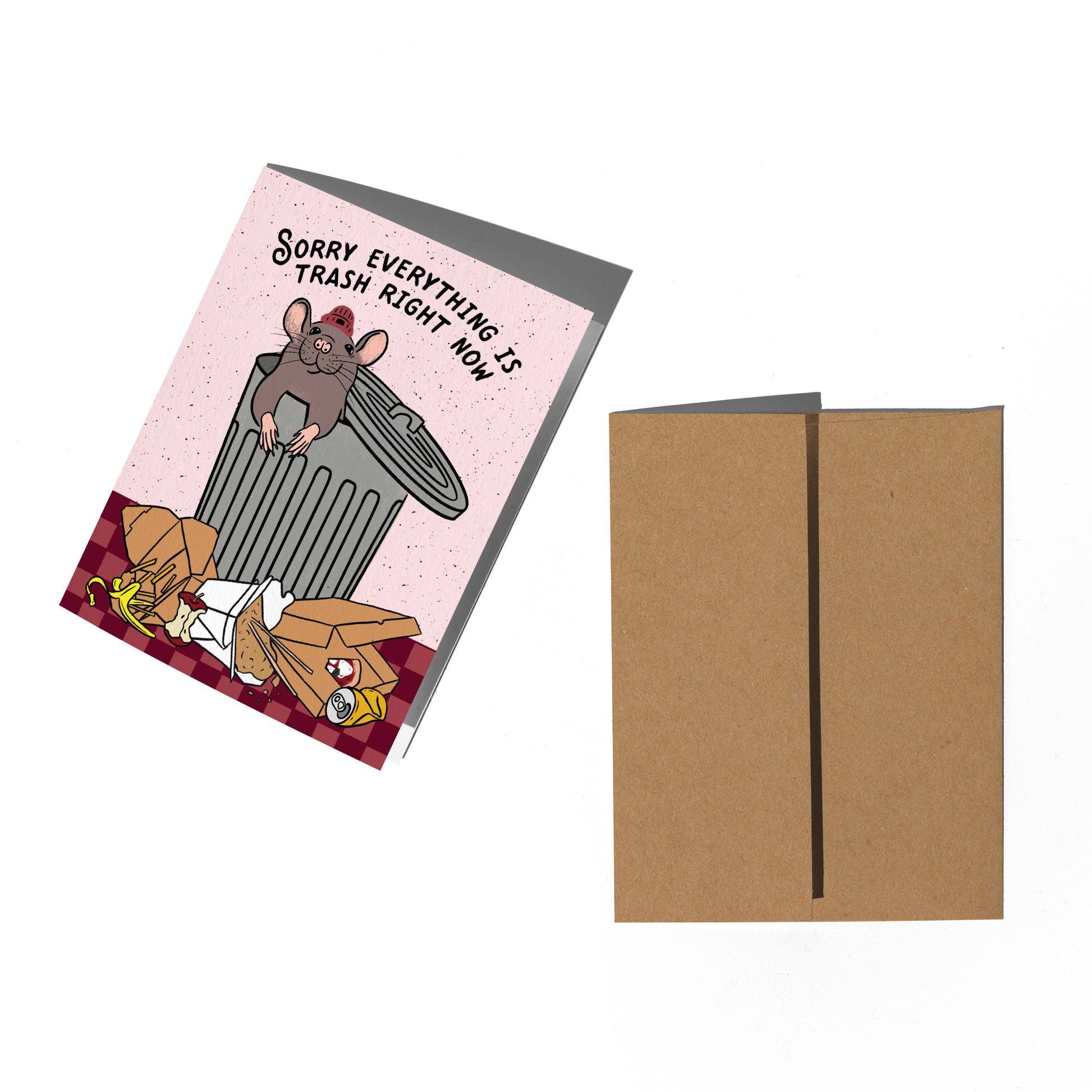 A greeting card and matching kraft envelope on a white background. The card features a pink background with a cartoon mouse sitting on a gray trash can, surrounded by trash, with the text 'Sorry EVERYTHING IS TRASH RIGHT NOW!'.