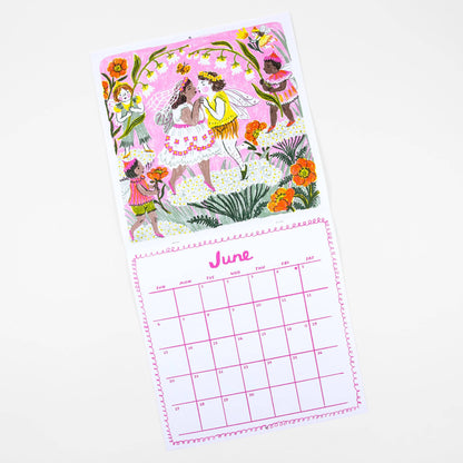 A single-page desk calendar shown on a clean white background. The top portion features a whimsical illustration of fairy-like characters in colorful dresses among flowers and plants, while the bottom portion shows a monthly calendar grid labeled June with pink lines and borders.