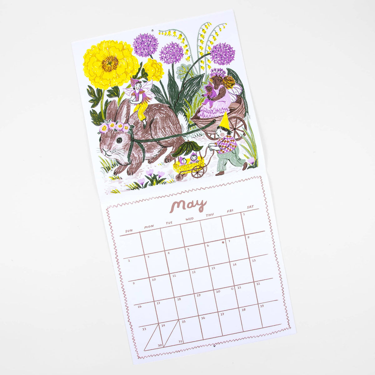 A single-page illustrated calendar spread on a white background, showing a colorful Easter scene with a rabbit, flowers, and children on the top half, and a May calendar grid on the bottom half.
