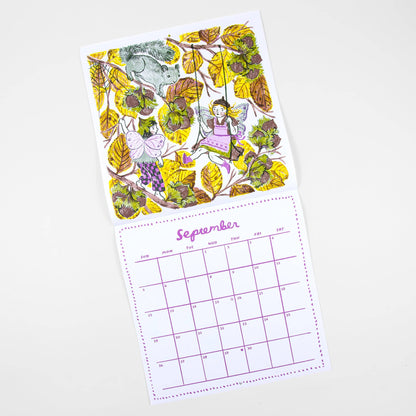 A children's monthly calendar page with a whimsical forest illustration on the front and a September calendar grid below, photographed on a clean white background.