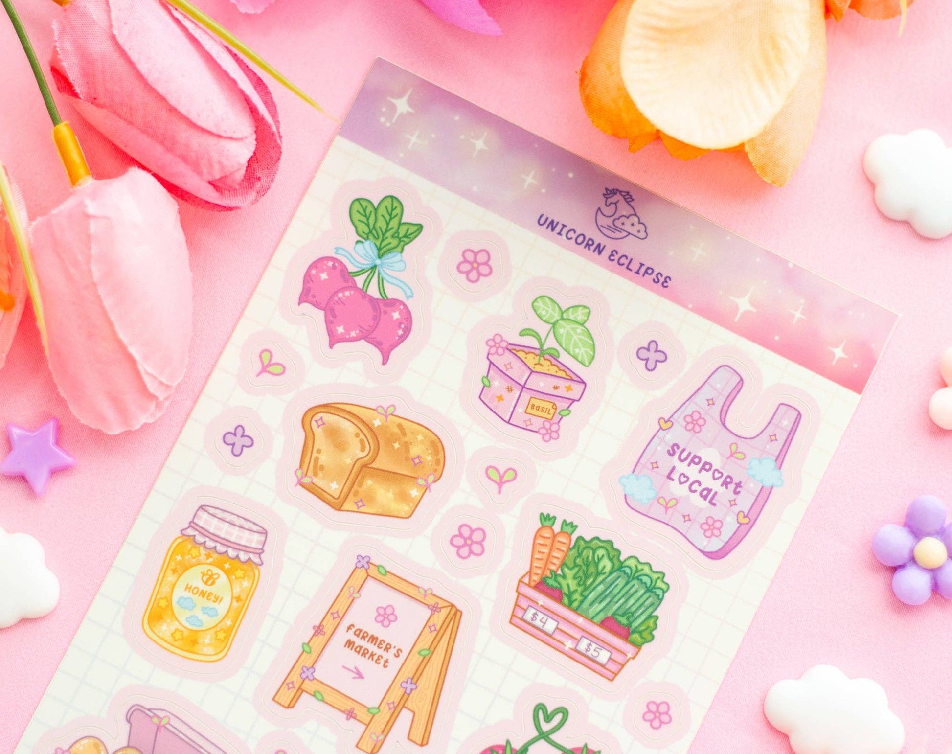 Sheet of colorful stickers with various designs on a pink background with flowers and candy.