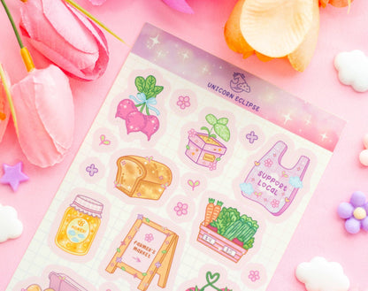 Sheet of colorful stickers with various designs on a pink background with flowers and candy.