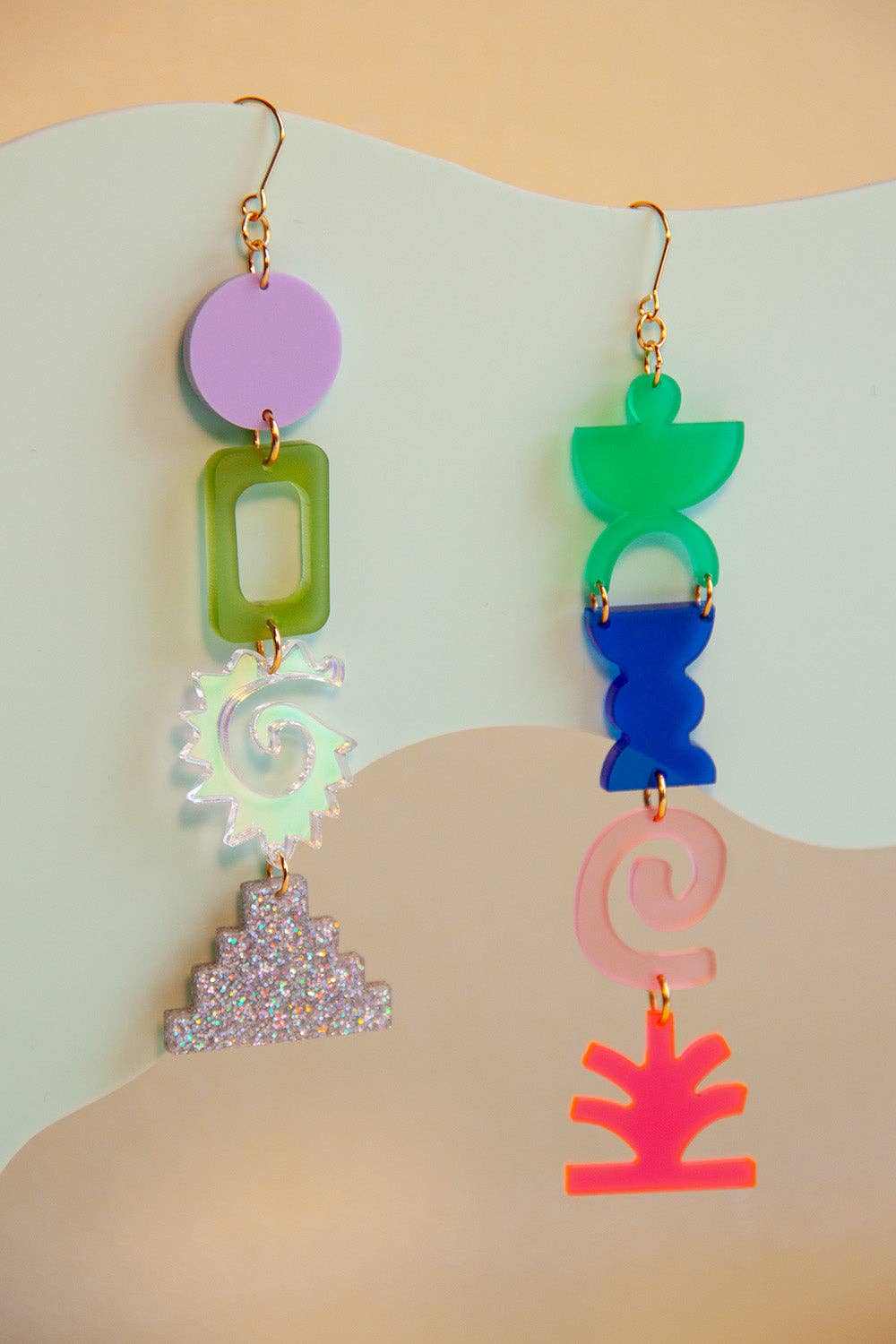 Colorful earrings with geometric shapes on a light background