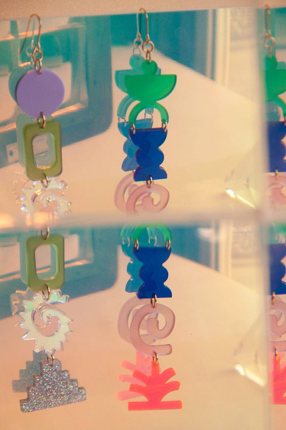 Colorful earrings on a clear stand with a blurred background