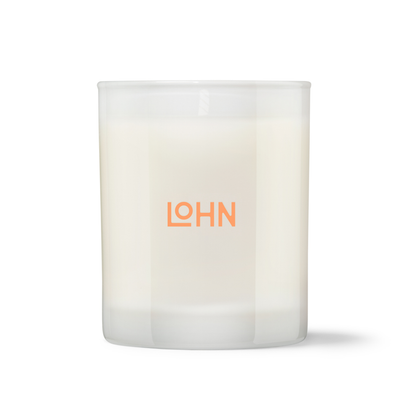 A frosted glass jar candle with off-white wax and the brand name 'LOHN' printed in orange on the front, set against a plain white background.