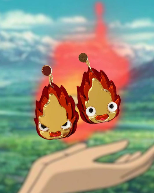 Flame-shaped earrings with a blurred landscape background