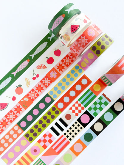 A set of colorful washi tapes with various patterns including fruit, fish, dots, stripes, and geometric shapes, arranged diagonally on a white background.