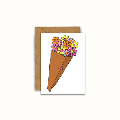 A white greeting card featuring a colorful illustration of a flower cone bouquet, shown with a brown kraft envelope on a light cream background.